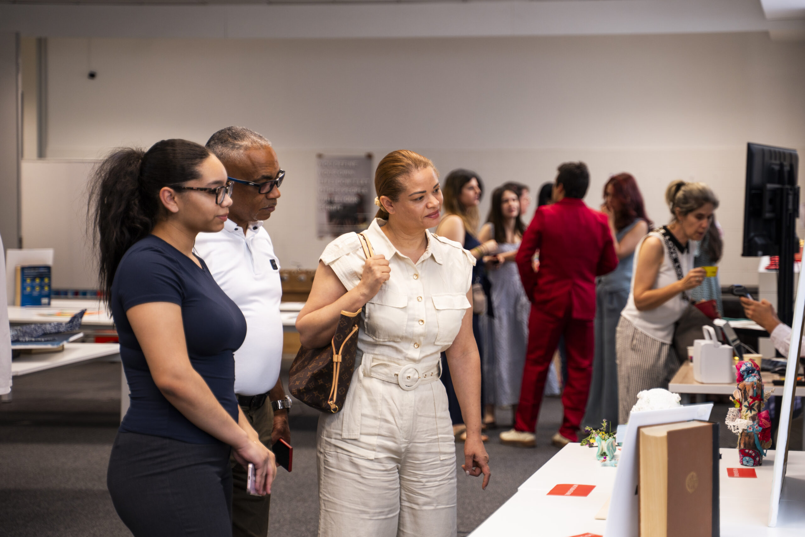 Familias y miembros de la comunidad de LMI College observando las obras durante la exposición de arte solidaria